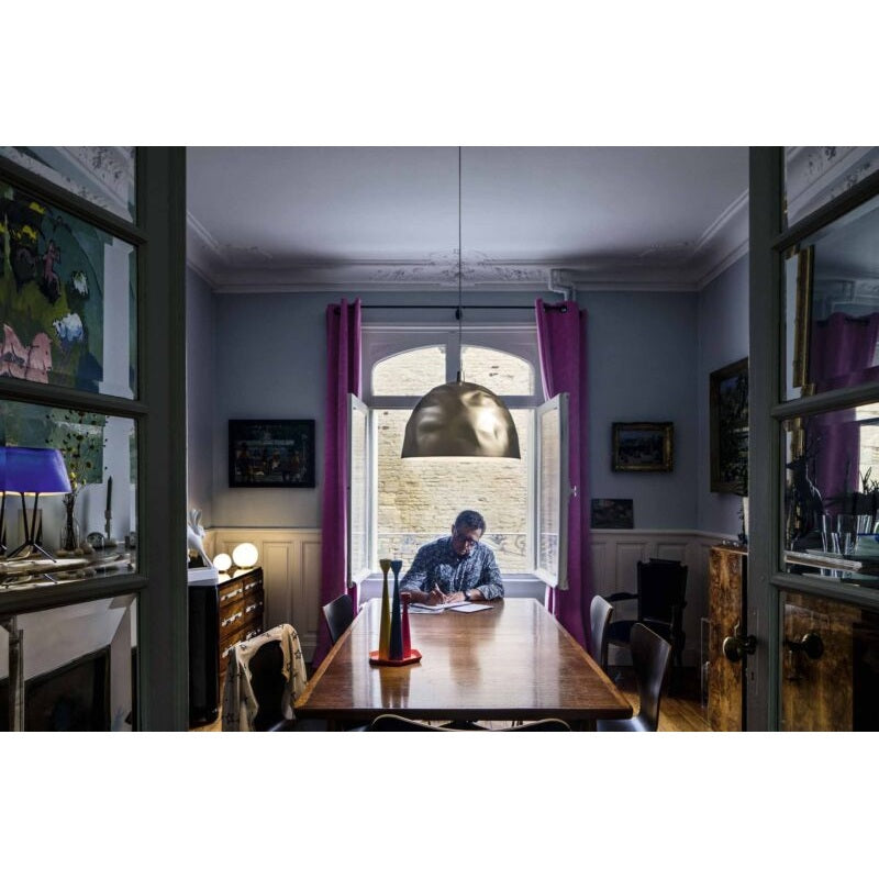 Foscarini Bump Pendelleuchte in Gold über einem Esstisch – Anwendungsbild